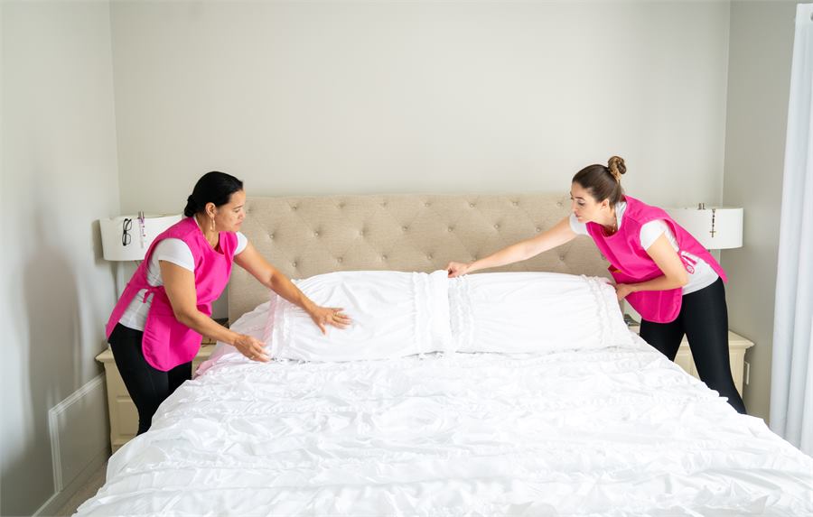Two Pro Shine team members making a bed